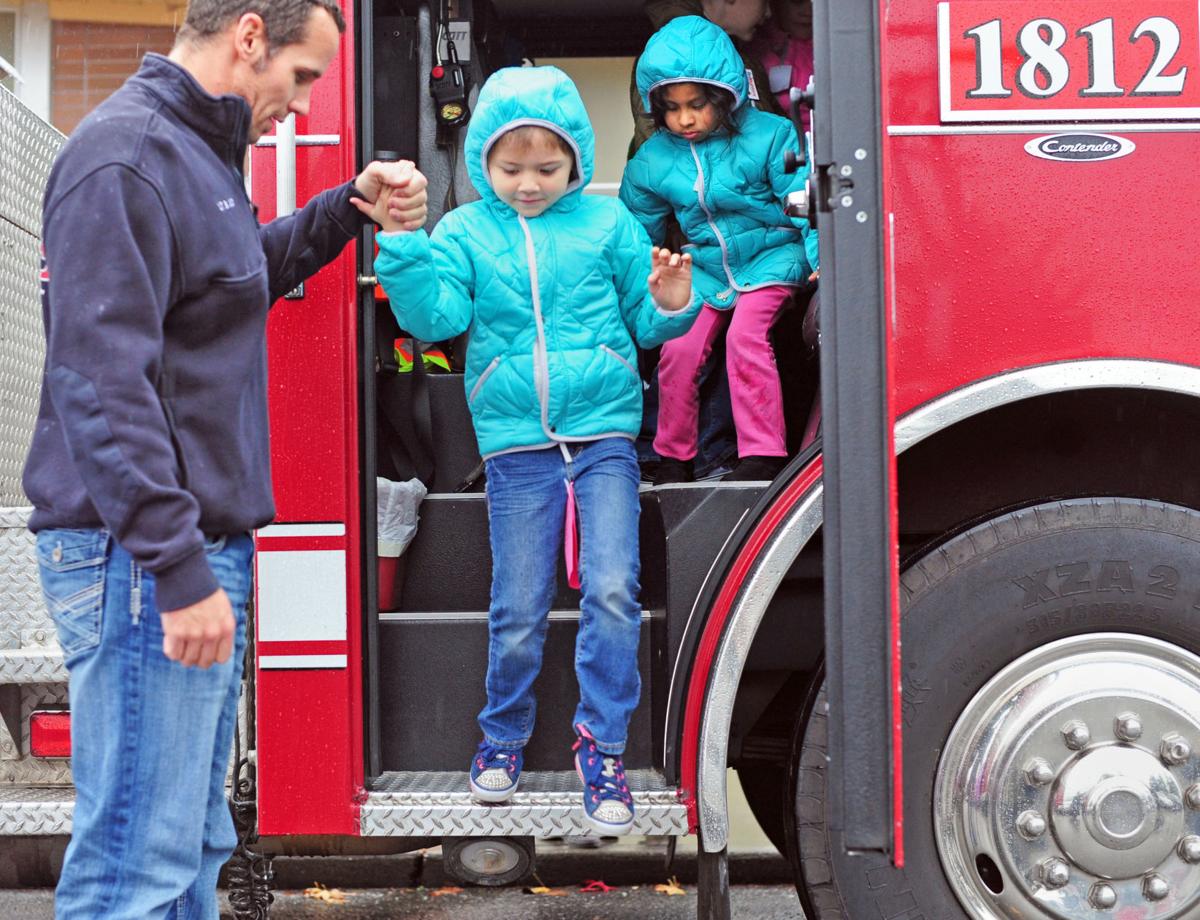 Firefighter Brad Judy helps students at Allen Elem in Bow during Operation Warm event at the school 